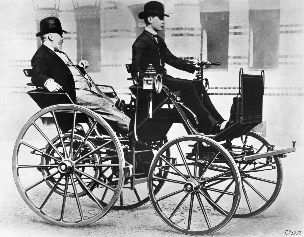 Gottlieb Daimler apoltronado en el asiento de atrás y su hijo Adolf conduciendo | Daimler AG