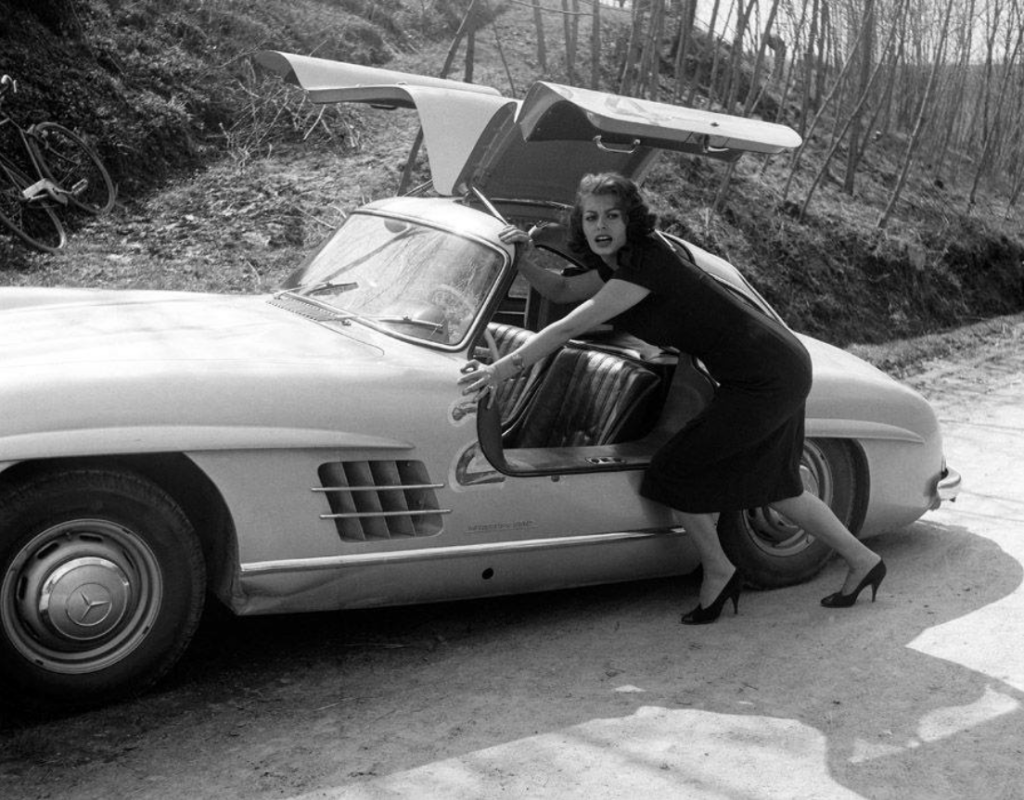 Sophia Loren empujando su Mercedes-Benz 300 SL en el Cinema Rally tras salirse de un curva para evitar a un espectador en 1956 | Carlo Bavagnoli/Mondadori
