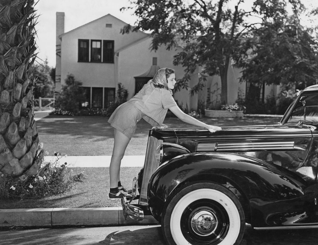 Judy Garland saca brillo a su Packard Six durante el rodaje de El Mago de Oz en 1939 | Frederic Lewis/Archive Photos/Getty Images