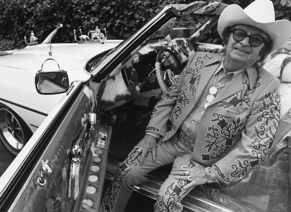 El diseñador de moda western Nudie Cohen sentado en su Pontiac descapotabe en 1971 | Marti Coale:BIPs:Getty Images