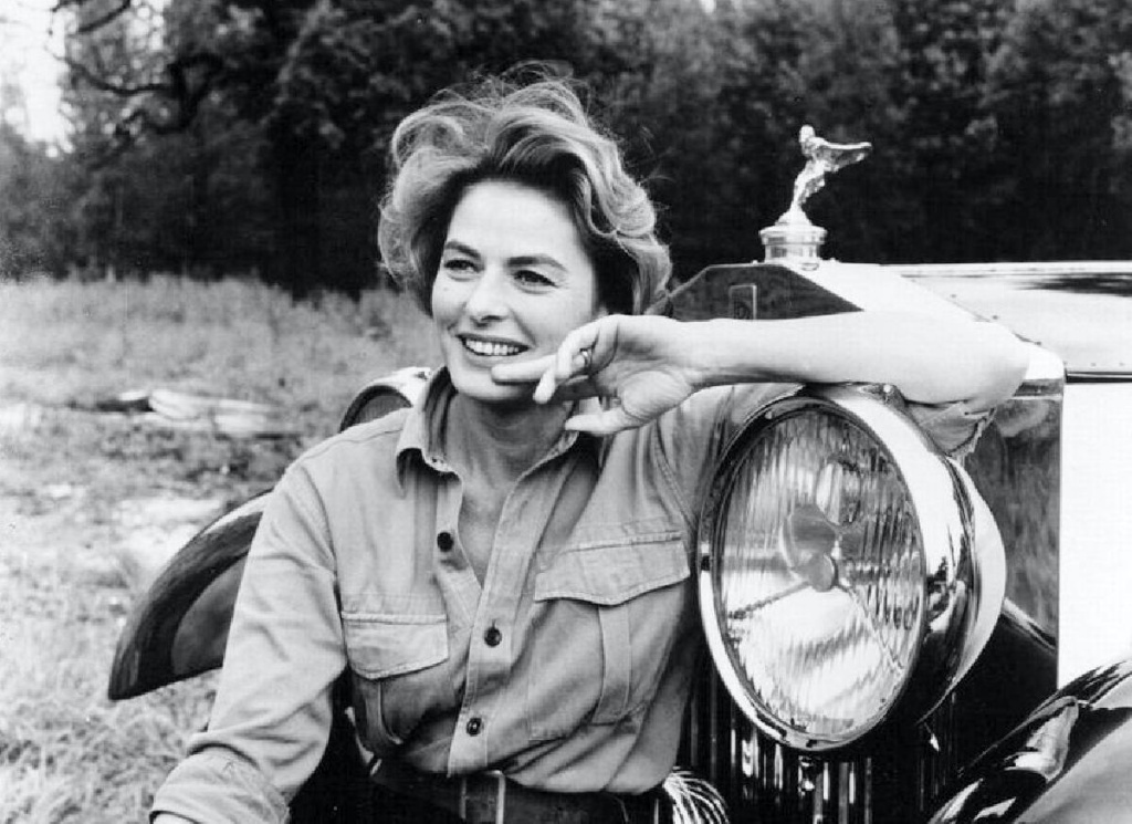 Ingrid Bergman sentada en el paragolpes de un Rolls-Royce en 1964 | Anthony Asquith