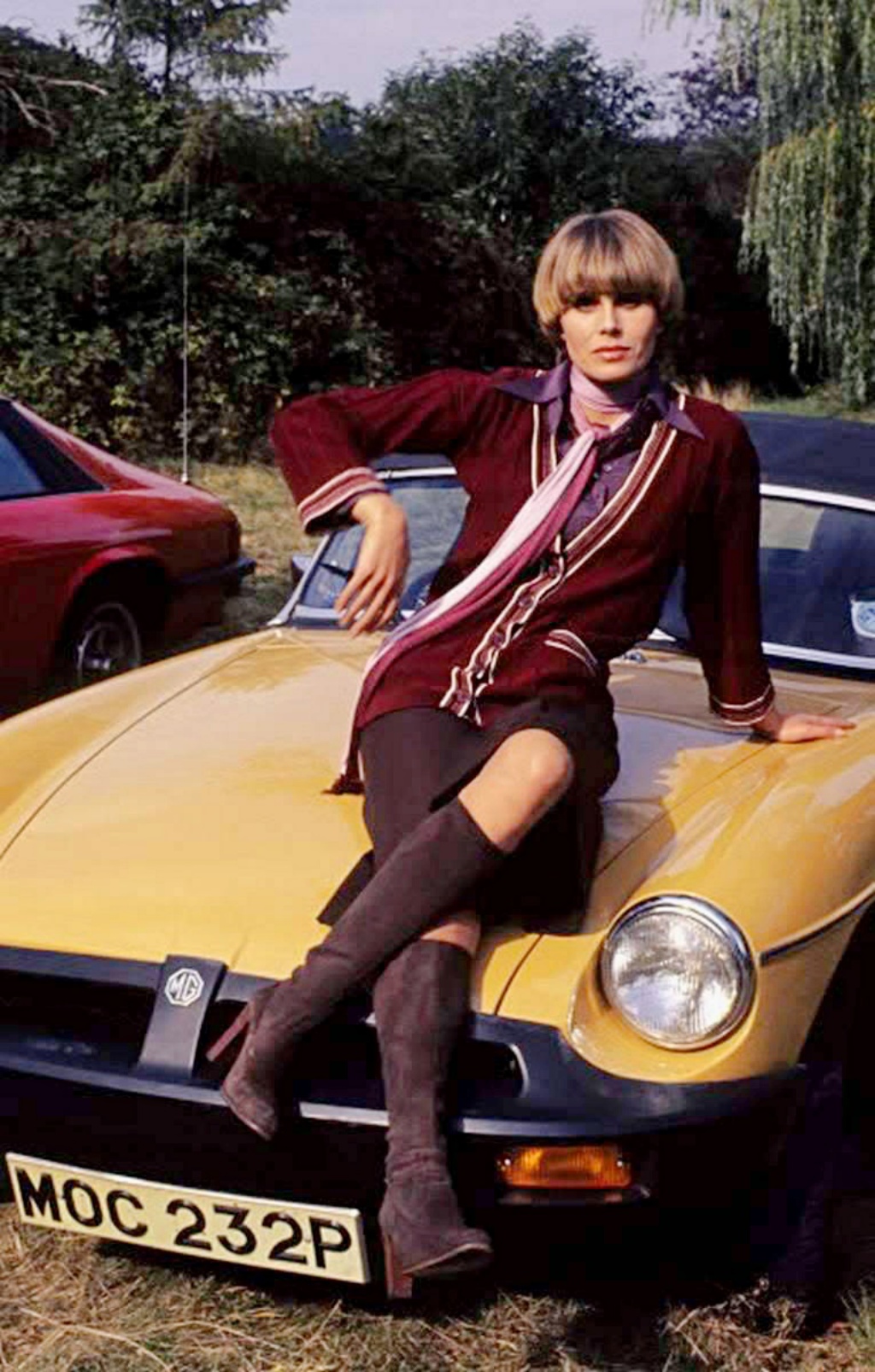 La actriz y presentadora británica Joanna Lumley sobre un MGB a mediados de los años 70