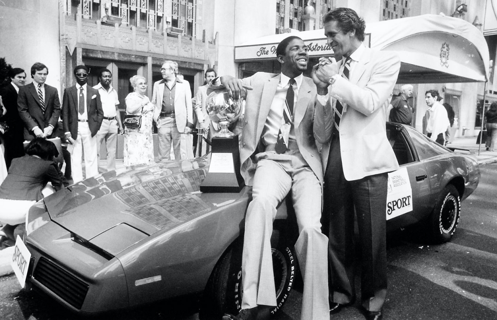 Magic Johnson acompañado por el entrenador de los Lakers Pat Riley, recibiendo un Pontiac Firebird TransAm como regalo tras ser nombrado Jugador del Año por NBA Sport Magazine en 1982