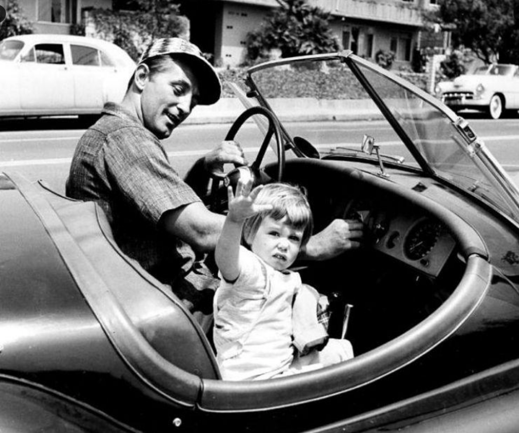 Personajes singulares y sus coches: Robert Mitchum con su hija Trini a bordo de su Jaguar XK140 hacia 1956